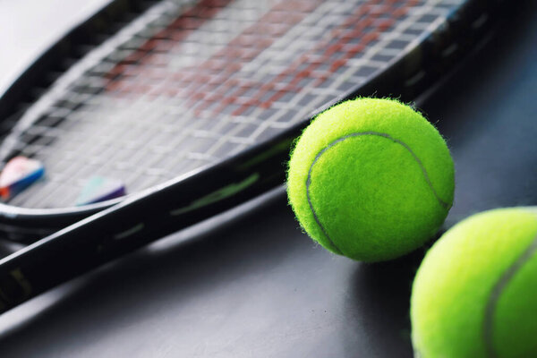 Спорт и здоровый образ жизни. Теннис. Желтый мяч для тенниса и ракетка на столе. Спортивный фон с теннисной концепцией.