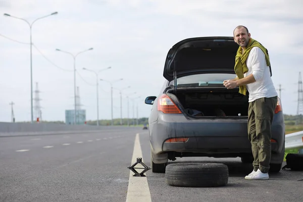 Ersätter Hjulet Bil Vägen Man Som Gör Däckarbete Vid Sidlinjen — Stockfoto