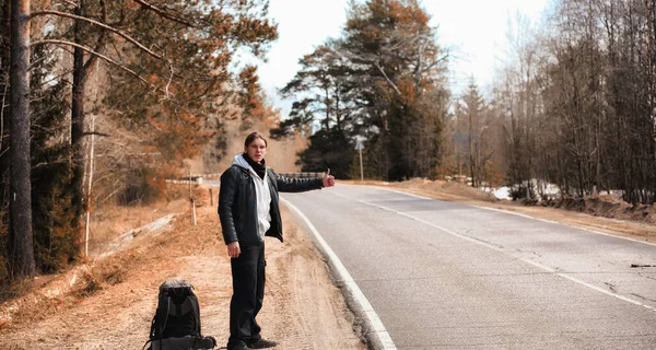 Młody Człowiek Jeździ Autostopem Kraju Facet Próbuje Złapać Przejeżdżający Samochód — Zdjęcie stockowe