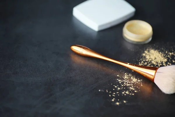 Powder and makeup brush. Brown powder on background. Makeup products. Style concept.