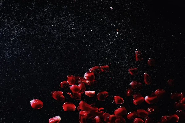 Olgun tatlı nar tohumlarına su damlaları düşer. Metnin için kopyalama alanı olan taze nar arkaplanı. Vejetaryen ve vejetaryen kavramı.