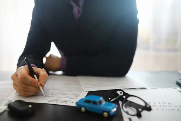 stock image The insurance agent signs a document. Car insurance policy. Auto insurance policy. Forms registration of the contract.