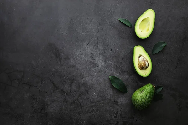 Avokado yemek tarifleri. Tahta kesme tahtasında servis edilen olgun yeşil avokado..