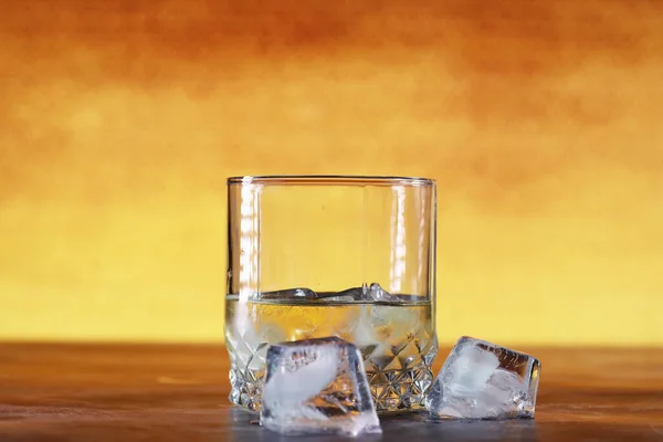 A glass of hard alcohol with ice on a bar counter. Whiskey with soda in glass. Advertising alcoholic drink.