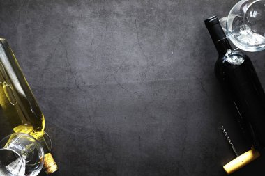 Masada bir bardak kırmızı şarap. Siyah şişe ve bir bardak şarap..