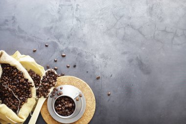 Bir poşet kahve. Kahve çekirdekleri masada kavrulmuş. Pişirmek için yapraklı kahve çekirdekleri.