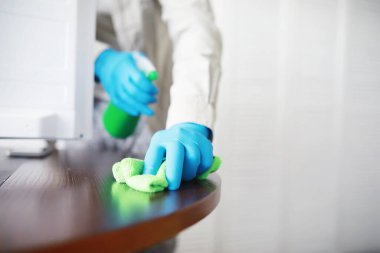 Ev temizliği konsepti. Yüzeylerin tozunu sil. Dezenfektan kapısı TV elektriğini kontrol ediyor. Evdeki karantinada hijyenik tedavi.