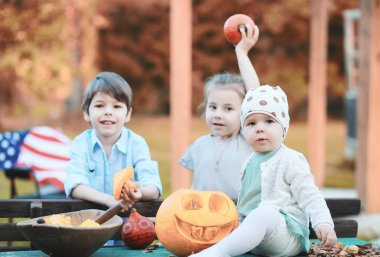 Sonbahar gelenekleri ve Cadılar Bayramı hazırlıkları. Doğada bir ev, masada balkabağından yapılmış bir lamba kesilir..