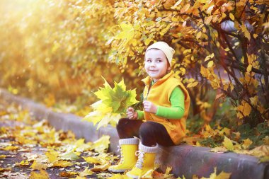 Sonbahar parkında yürüyen küçük kız 