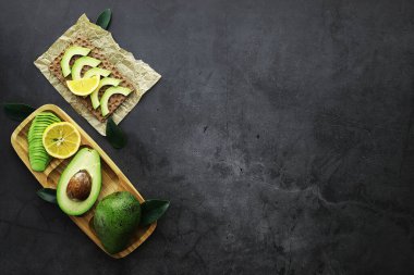 Avokado yemek tarifleri. Tahta kesme tahtasında servis edilen olgun yeşil avokado..