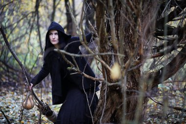 Bir kadın bir ritüel üzerinde yoğun bir orman içinde bir cadı elbiseli