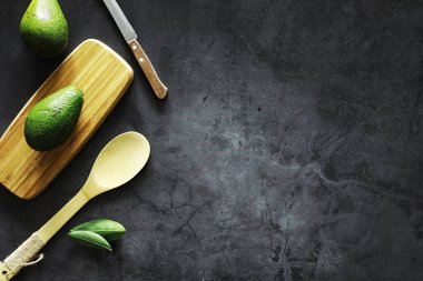 Avokado yemek tarifleri. Tahta kesme tahtasında servis edilen olgun yeşil avokado..