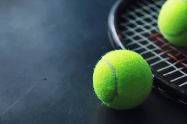 Spor ve sağlıklı yaşam tarzı. Tenis mi? Tenis için sarı top ve masada raket. Tenis konsepti olan spor geçmişi.