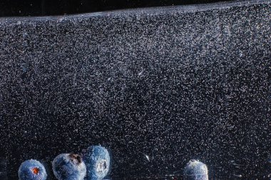 Olgun tatlı yaban mersinine su damlası. Metnin için fotokopi alanı olan taze yabanmersini arkaplanı. Vejetaryen ve vejetaryen kavramı. Yabanmersini dokusunun makro dokusu.