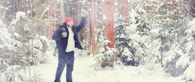 Bir adam sırt çantasıyla seyahat eder. Ormanda kış yürüyüşü. Kışın parkta yürüyüş yapan bir turist..