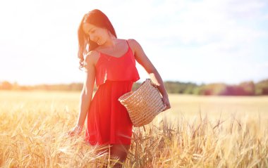 Buğday tarlasında genç bir kız. Yaz manzarası ve kırsalda doğa yürüyüşü yapan bir kız. Köyde dinlenin.