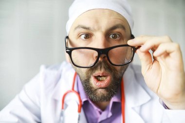 Şaşı sakallı bir adam çerçeveye bakıyor. Göz hastalığı. Çılgın tıp uzmanı kavramı. Doktor komşu..