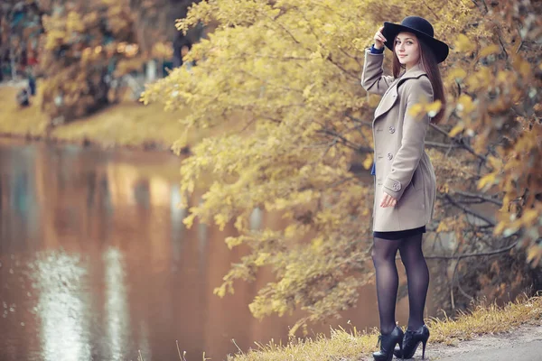 穿着外套的小女孩在秋天的公园里散步 — 图库照片
