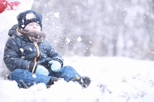 孩子们第一次下雪时在公园里散步 — 图库照片