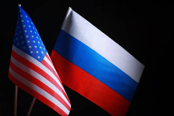 The concept of diplomatic relations. Flag of the United States of America and Russian Federation. Sanctions pressure in politics.