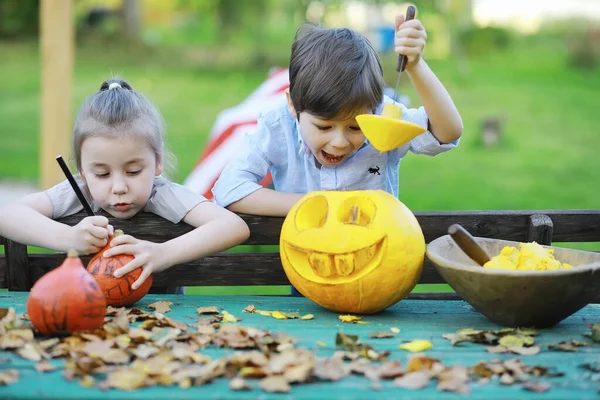 Autumn traditions and preparations for the holiday Halloween. A house in nature, a lamp made of pumpkins is cut out at the table.