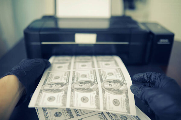 The concept of global economic crisis. Illegal production of US dollars. Print money underground. Printing hundred dollar bills by a criminal.