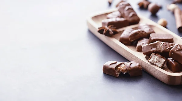 バックライトの黒の背景にチョコレートバー チョコレートを詰め込む お菓子や紅茶の甘いお菓子 — ストック写真