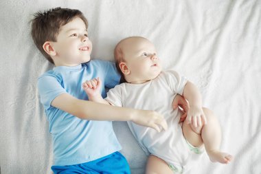 Çocuklar yeni doğan bebeğin yanında yatar, küçük kardeşim. Çocukların duyguları..