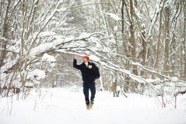 Kışın ormanda bir adam. Sırt çantalı bir turist kışın ormana gider..