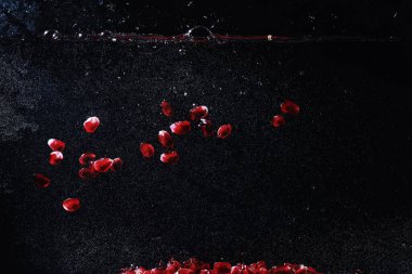 Olgun tatlı nar tohumlarına su damlaları düşer. Metnin için kopyalama alanı olan taze nar arkaplanı. Vejetaryen ve vejetaryen kavramı.