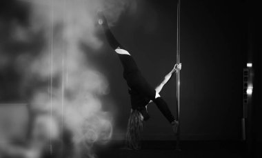 Spor aletleri üzerinde egzersiz yapan bir kız. Stüdyodaki direğin üstündeki dansçı..