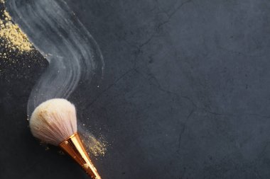 Toz ve makyaj fırçası. Arka planda kahverengi toz. Makyaj ürünleri. Biçim konsepti.