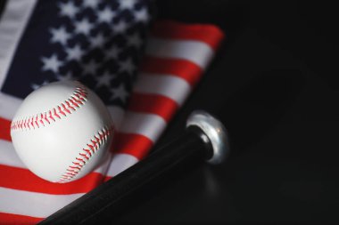 Amerikan geleneksel spor oyunu. Beyzbol mu? Kavram. Amerikan bayrağıyla birlikte beyzbol topu ve sopalar masada..