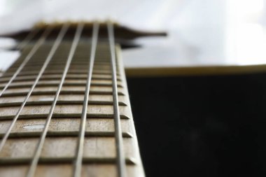 Sahnede telli bir enstrüman çalan sanatçı için akustik gitar. Capo 'lu siyah gitar. Müzik arkaplanı.