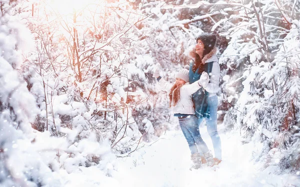 年轻的家庭散步 妈妈和女儿在雪地的公园里散步 — 图库照片