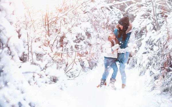 年轻的家庭散步 妈妈和女儿在雪地的公园里散步 — 图库照片