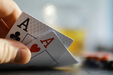 Para için kumar kartı oyunları. Texas Poker Pokeri. Eldeki kartlar, oyun fişleri, bardaktaki bir deste alkol..