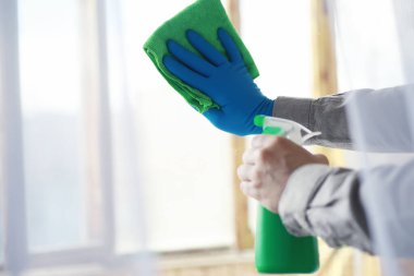 Ev temizliği konsepti. Yüzeylerin tozunu sil. Dezenfektan kapısı TV elektriğini kontrol ediyor. Evdeki karantinada hijyenik tedavi.