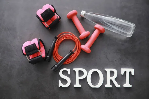 Sport and healthy lifestyle. Accessories for sports. Yoga mat dumbbell and jump rope. Sports background with home exercises concept.