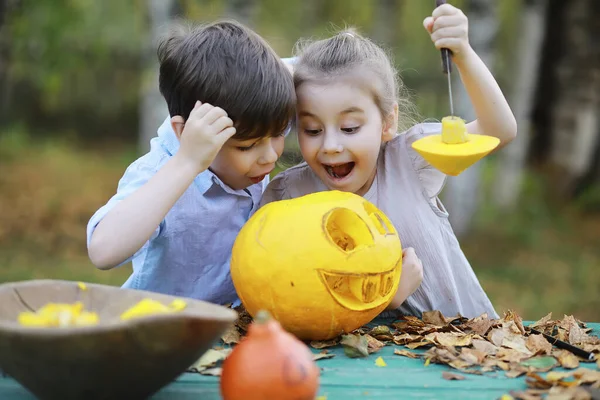 Autumn traditions and preparations for the holiday Halloween. A house in nature, a lamp made of pumpkins is cut out at the table.