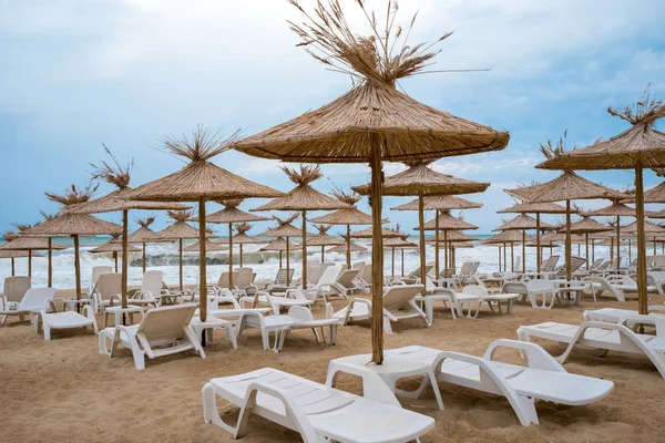 Пляжные зонтики с шезлонгами на пляже — стоковое фото