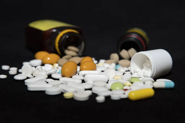 Pillen aus Tablettenflaschen geschüttet Stockbild