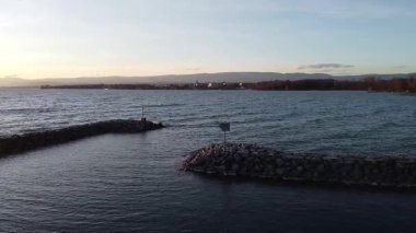 Lozan 'daki sağlam rıhtımların ve dalga kırıcıların havadan görünüşü Cenevre Gölü' nün sakin sularını koruyor. Taş yapılar güneşin altında hafif dalgalara karşı parıldıyor..