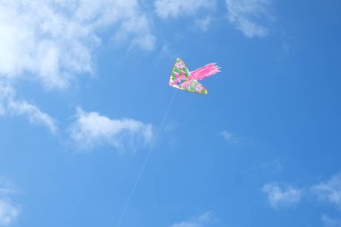 Mavi gökyüzüne uçan kırmızı bir uçurtma