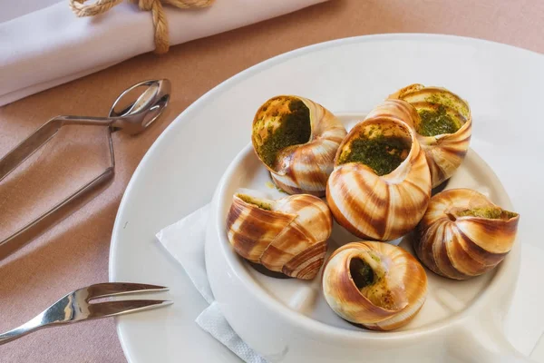 Delicioso bourguignonne caracol au gratin. plato con caracoles. tenedor para caracoles —  Fotos de Stock