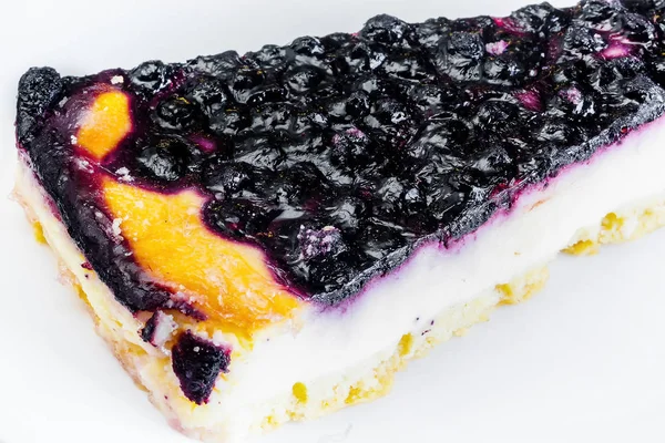 Blaubeer-Käsekuchen auf weißem Teller lizenzfreie Stockbilder