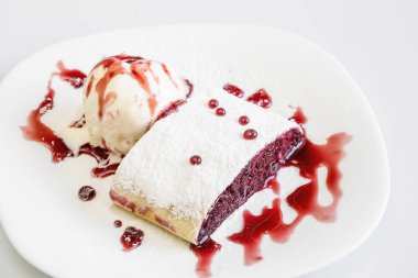 Lezzetli tatlı siyah arka plan ile Tabak üzerinde dondurma topu ile Tatlı kiraz strudel