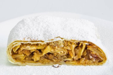 Beyaz tabakta elma strudel, kek şeker serpilir. beyaz arka plan.