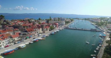 Omis kasabası, Hırvatistan. Deniz manzarası ve şehir hayatı yukarıdan. Hırvatistan 'ın güneyindeki Omis kıyı kasabasının insansız hava aracı görüntüsü. Omis kasabasındaki Cetina Köprüsü 'nde şehir trafiği.