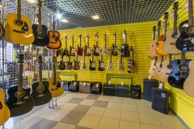 Gitar, akustik ve elektrik modern bir müzik dükkanında satırları